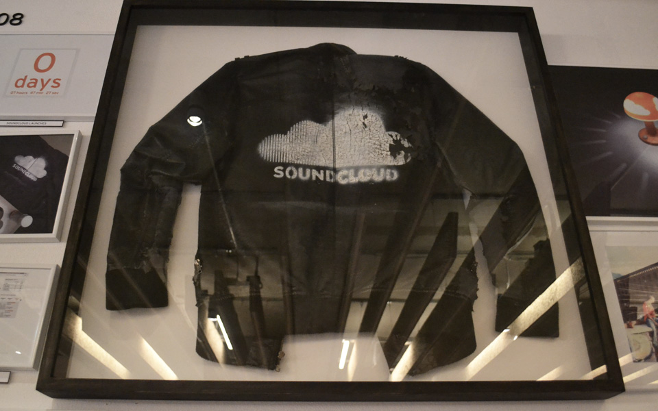 Primeiro moletom de Alexander Llung, criador do Soundcloud, com o logo da empresa. Na cozinha, um mural reúne toda a história