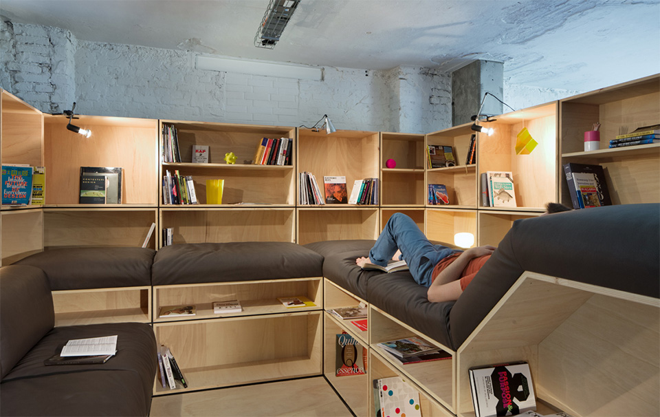 O escritório conta com uma pequena biblioteca. Na prateleira, alguns livros de design e revistas alemãs