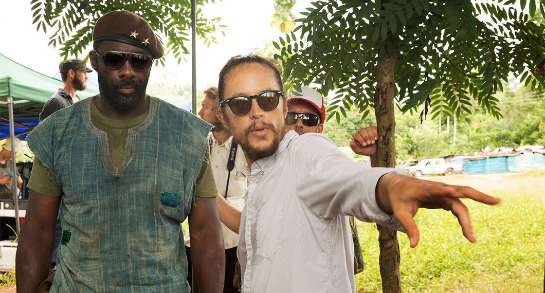 O diretor Cary Joji Fukunaga no set com Idris Elba